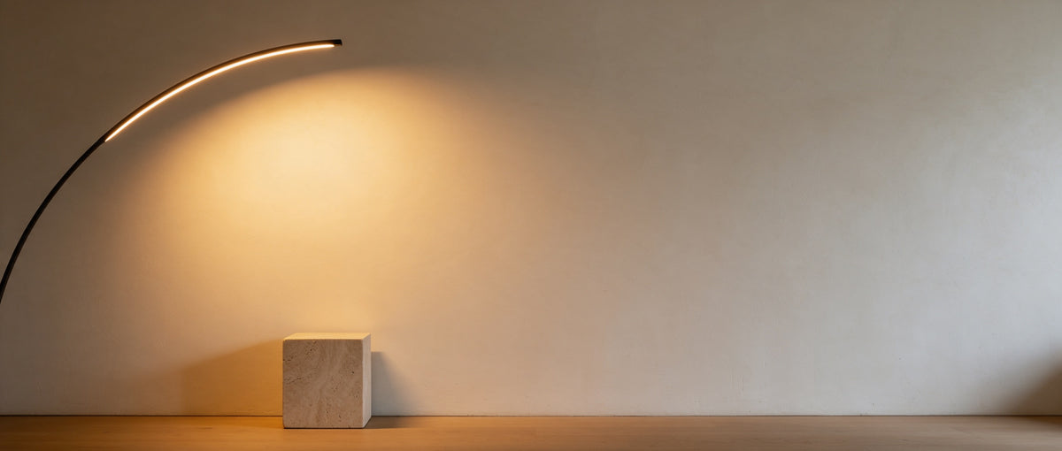 Warmer Lichtverlauf einer Bogenleuchte auf einer hellen Putzwand