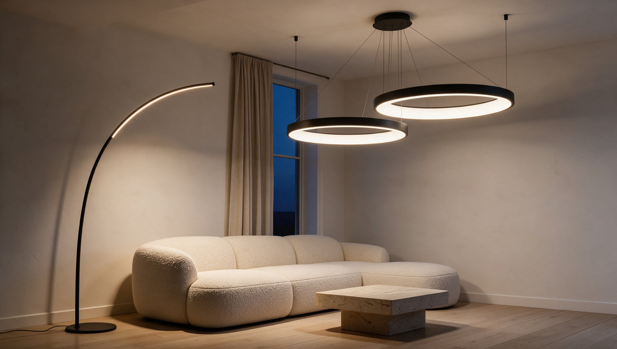 Wohnraum am Abend mit schlanker Bogen-Stehleuchte und Ringpendelleuchte von Lunae Design